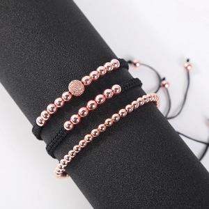 Detailed macro view of three rose gold beaded bracelets with micro-pave zircon on black cord