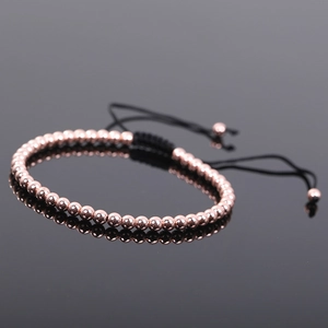 Close-up of rose gold beaded adjustable bracelet with black braided cord and smooth finish