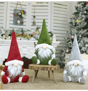 Dettaglio di tre gnomi natalizi festivi in rosso, verde e grigio con barbe di pelliccia