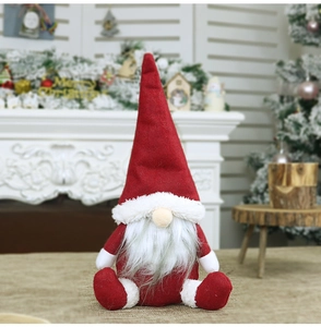 Dettaglio di gnomo natalizio in peluche con cappello rosso e barba in finta pelliccia
