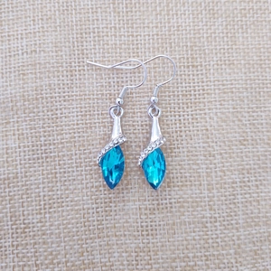 Detailed view of silver water drop earrings with faceted blue crystal and white rhinestones