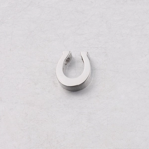 Close-up of horseshoe-shaped stainless steel pendant bead with polished mirror finish