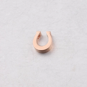 Close-up of polished rose gold horseshoe-shaped metal pendant for DIY jewelry design