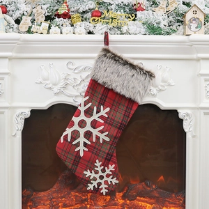 Classic plaid Christmas stocking with white faux fur cuff hanging on a cozy white fireplace