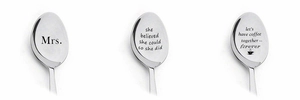 Detailed view of custom engraved stainless steel spoons with various romantic text patterns