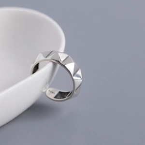 Macro detail of S925 sterling silver minimalist rivet ring with punk style open band