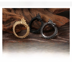 Detailed view of three punk dragon head rings in gold, black and steel finishes
