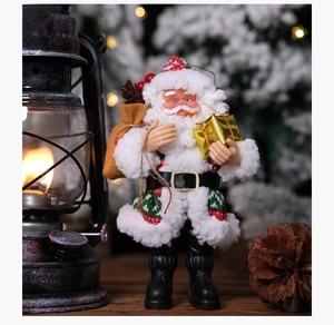 Close-up of standing Santa figurine with gift bag and golden box in festive setting
