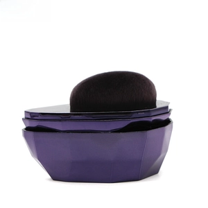 Detailed macro view of the purple geometric faceted base and high-density foundation brush