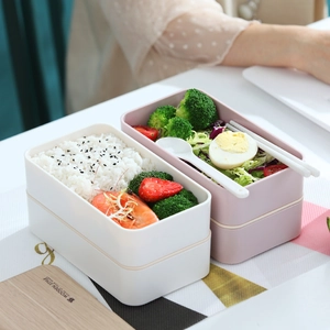 Modern double-layer stackable bento lunch box with white utensils and wooden lid design