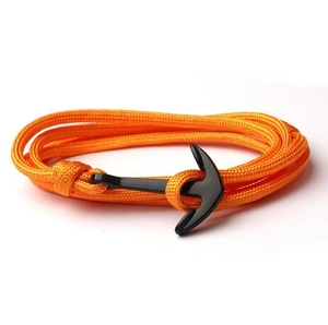 Dettaglio del bracciale in nylon arancione intrecciato con chiusura ad ancora in metallo nero