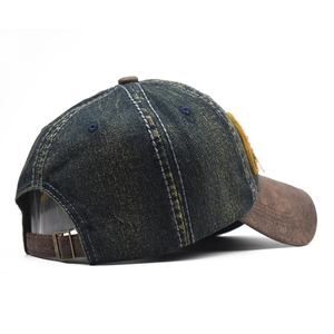 Detail of vintage denim baseball cap with brown suede brim and adjustable metal buckle