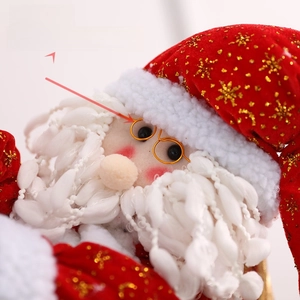 Close-up of Santa Claus hanging ornament with golden spectacles and glittery fabric