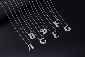 Close-up of sparkling silver-tone letter A to G pendants with pavé set crystals