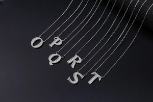 Macro shot of custom alphabet pendants O to T with sparkling pave-set zircons
