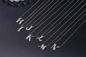 Detail view of silver alphabet necklaces H to N with sparkling micro-pave crystals