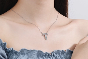 Close-up of a silver letter T pendant necklace with sparkling rhinestones on model