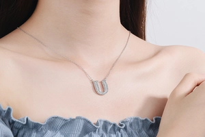 Detailed view of capital letter U necklace pendant with sparkling zircon micro-pave setting