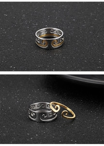 Detail of two-piece golden cloud ring and silver textured band set on black background