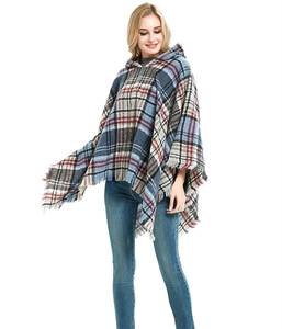 Dettaglio di poncho con cappuccio a quadri rosso e blu con bordo a frange morbide