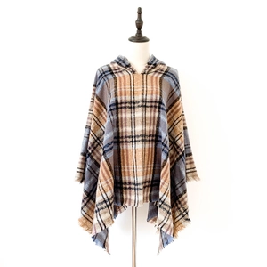 Dettaglio del poncho con cappuccio a quadri con orlo a frange in marrone e blu