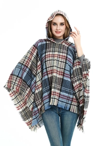 Dettaglio di un poncho con cappuccio a quadri con frange in blu, rosso e beige