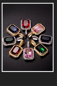 Macro view of rectangular emerald cut pendants with vibrant colorful stones and zircon halo