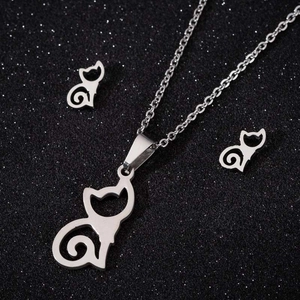 Detailed view of silver cat necklace and earrings set on a starry black background