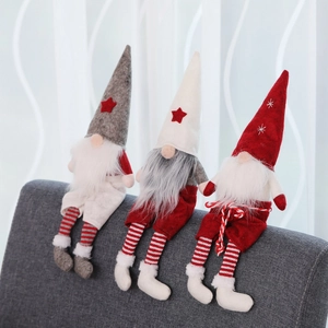 Three Christmas gnomes with pointed hats and long striped legs sitting on grey fabric