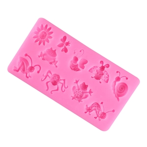 Macro detail of pink silicone mold featuring bee, butterfly, and flower patterns