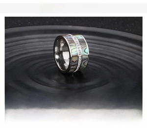 Macro detail of punk style stainless steel ring with abalone shell inlay and rhinestones