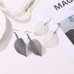 Detailed view of long hollow leaf earrings featuring delicate leaf vein patterns in silver and black