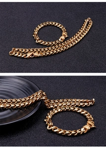 Detail view of gold Cuban link chain necklace and bracelet with dragon head clasps