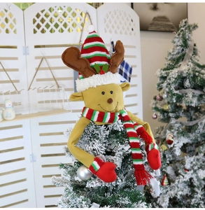 Close-up of reindeer Christmas tree topper with brown antlers and a striped knit hat