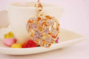 Macro detail of gold-plated hollow heart keychain with sparkling rhinestones and stars