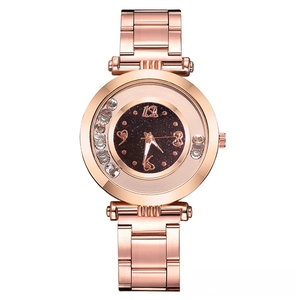 Close-up of rose gold watch dial with starry sky background and floating crystals