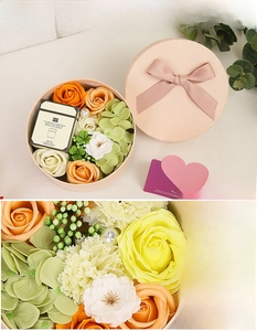 Detail of yellow soap rose flower box with scented candle and elegant pink round gift case