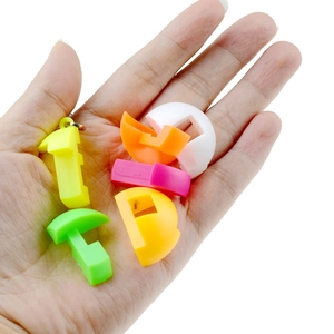 Detail of colorful plastic puzzle cube keychains held in hand with matte finish texture