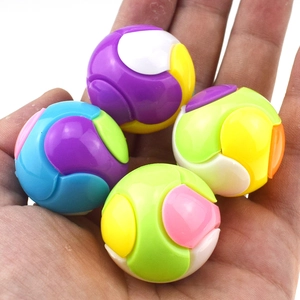 Close-up of four colorful DIY puzzle balls held in hand showing compact size and texture