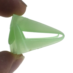 Close-up of a small light green plastic arrow-shaped clip for props and toy fixing