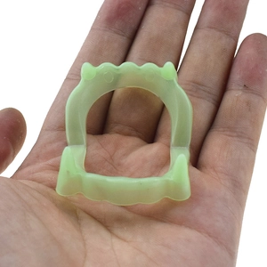 Glow-in-the-dark vampire teeth prop made of soft green material for Halloween parties