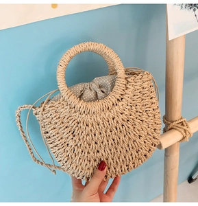 Handmade straw woven handbag detail showing round handle and cute polka dot inner lining fabric.