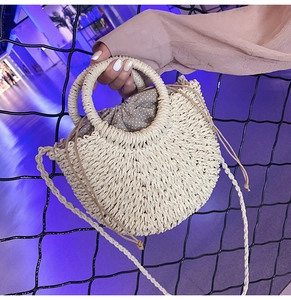 Handmade straw woven half-moon handbag detail, featuring round handles and cute polka dot pouch.