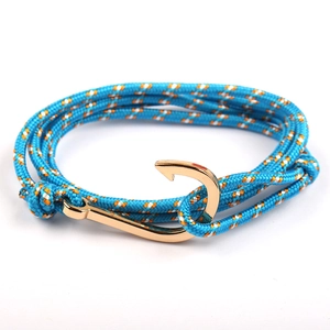 Detail of blue nautical rope bracelet featuring a golden fish hook metal clasp