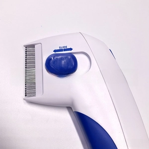 Detail of pet flea comb with slide button mechanism and fine metal teeth for dogs