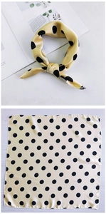 Detailed view of a yellow silk square scarf with black polka dots shown tied and flat