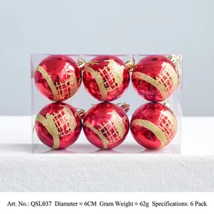 Detail of red Christmas baubles in box featuring gold glitter cedar patterns