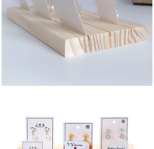Detail view of wooden earring display stand with parallel slots and natural grain texture