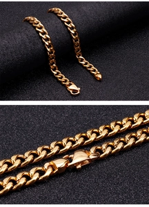 Detail view of golden Cuban link necklace with secure lobster clasp on black background