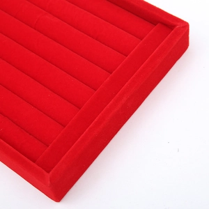 Close-up of red velvet jewelry tray featuring seven parallel rows for ring storage
